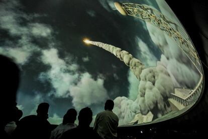 Espectadores y medios de comunicación asisten a la ceremonia de apertura de una exposición espacial en el Birla Planetarium de Calcuta, en India.