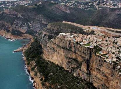 La urbanización Cumbres del Sol, en el término municipal de Benitaxell, se alza al borde de uno de los acantilados que jalonan la costa al sur del Cabo de La Nao. La vista aérea de la urbanización y de las construcciones al fondo revela la masiva ocupación urbanística en la comarca de la Marina Alta.