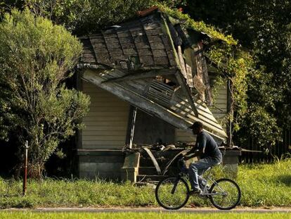 Un hombre pasa en bicicleta por delante de una casa abandonada en el distrito 9 de Nueva Orleans, el pasado día 1.