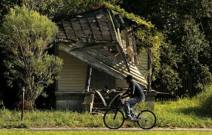 Un hombre pasa en bicicleta por delante de una casa abandonada en el distrito 9 de Nueva Orleans, el pasado día 1.