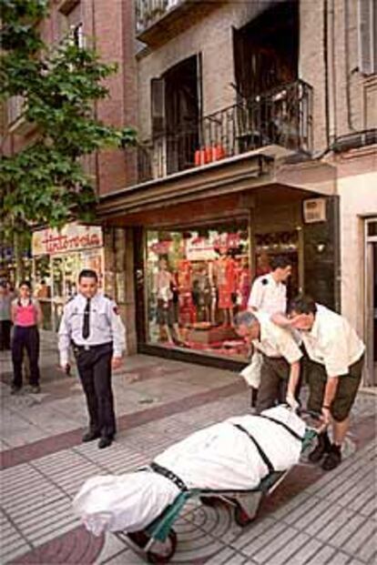 Empleados de la funeraria sacan de la casa siniestrada el cadáver de Ana Peral.