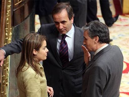 La portavoz del PP, Soraya Sáenz de Santamaría, conversa con los socialistas José Antonio Alonso y Ramón Jáuregui ayer en el Congreso.