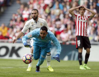 El portero costarricense del Real Madrid Keylor Navas intenta atrapar el balón ante la mirada de su compañero, Daniel Carvajal y el defensa del Athletic de Bilbao Iñigo Lekue durante el partido de la vigésimo octava jornada de la Liga que disputan en el estadio San Mamés.