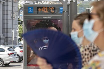 La ola de calor continúa este jueves en España con un registro de temperaturas extremas de entre 5 a 10 grados por encima de las normales para esta época en muchos puntos de la geografía y a la espera de que sigan subiendo mañana y el sábado. En la imagen, un grupo de mujeres, en una parada de autobús de Madrid.