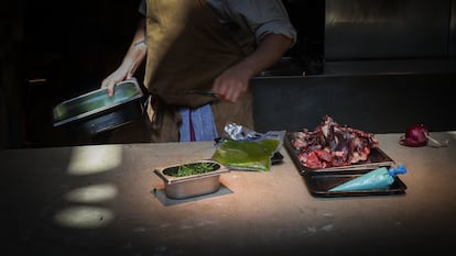 Un chef coloca restos de comida sobre la plancha de la cocina para transformarlos en nuevos platos en el restaurante Tramo de Madrid.