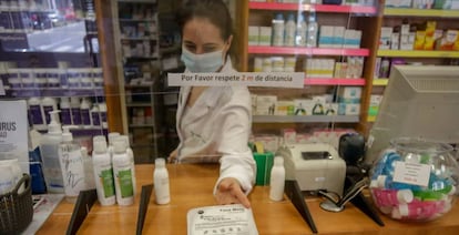 Una farmacéutica entregando mascarillas.