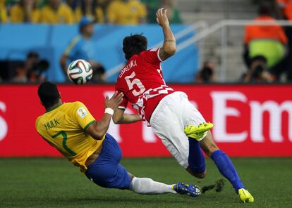 El brasileño Hulk disputa el balón con Vedran Corluka.