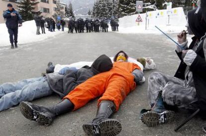 Manifestantes se tumban en la calle, en Basilea, durante una protesta contra el Foro de Davos.