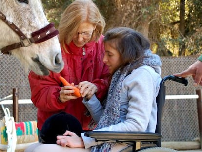 Teresa Xipell, hipoterapeuta en la Fundación Federica Cerdá, con una alumna.