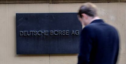 Un hombre camina junto a una placa de la empresa financiera Deutsche Börse AG en Fráncfort (Alemania).