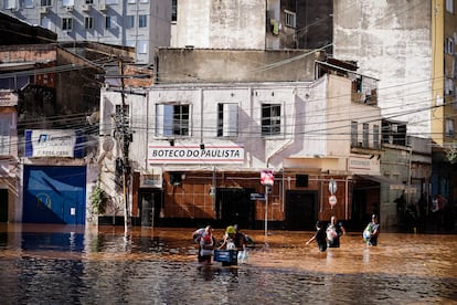 Habitantes de Porto Alegre caminan por las calles inundadas de la ciudad, el 6 de mayo.