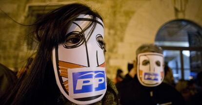 Dos participantes en la manifestaci&oacute;n contra el cierre de Canal 9 y R&agrave;dio Catalunya con m&aacute;scaras contra el PP.