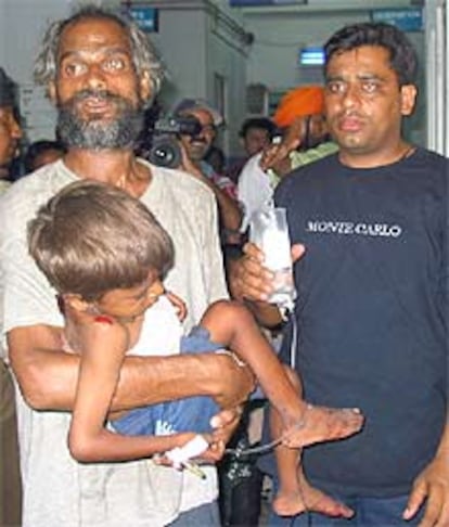 Un indio sostiene a su hijo, herido en el ataque a un templo hindú, mientras espera en un hospital de Jammu.
