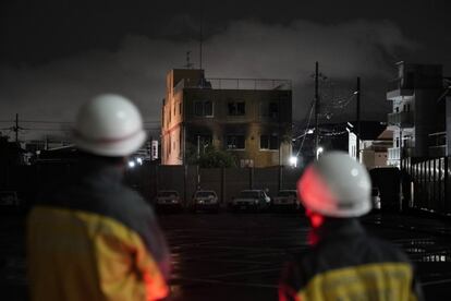 Dos voluntarios miran el edificio de la empresa Kyoto Animation, destruido tras un incendio intencionado, en Kioto (Japón). El incendio empezó a las 10.30 hora local (las 03.30 en la España peninsular), cuando un hombre cuya identidad no ha sido revelada entró en la sede de Kyoto Animation y, tras arrojar gasolina, prendió fuego al inmueble al grito de “¡morid!”. Al menos 33 personas fallecieron y 40 resultaron heridas.