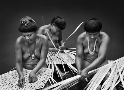 Mujeres korubo trabajando. Luni, a la izquierda, con un mico nocturno en la cabeza.