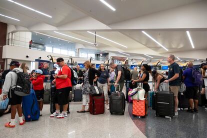 Pasajeros esperan en fila para intentar volver a reservar sus vuelos en el Aeropuerto Internacional Hartsfield Jackson, en Atlanta.