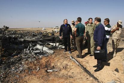 Los ministros Vladimir Puchkov, izquierda, y Maxim Sokolov, quinto por la derecha, examinan los restos del avión que se estrelló en Hassana, Egipto.