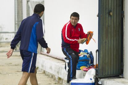 Un utillero limpia las botas de los jugadores tras el entrenamiento.