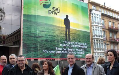 Dirigentes del PNV, con Urkullu en el centro, delante de Sabin Etxea, en cuya fachada aparece una lona con el nuevo logotipo.