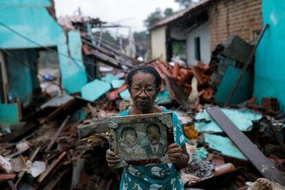 Vitoria Rocha, de 81 años, posa con la foto de sus padres luego de encontrarla entre los escombros de su casa, donde vivió casi 40 años y que fue destruida por las inundaciones, en Itambé.