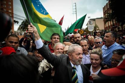 O ex-presidente Lula segura uma bandeira do Brasil na chegada ao Tribunal de Justiça Federal em Curitiba. Ele estará pela primeira vez frente a frente com o juiz Sergio Moro.