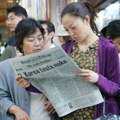 Dos mujeres leen una edición especial sobre la prueba nuclear, en Tokio.