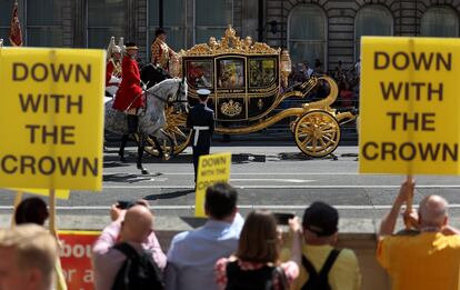 Manifestantes contra la Monarquía, al paso del caruaje que traslada a Carlos III y la reina Camila. 