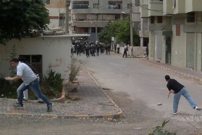 Dos hombres lanzan piedras contra la policía en la ciudad de Banias.