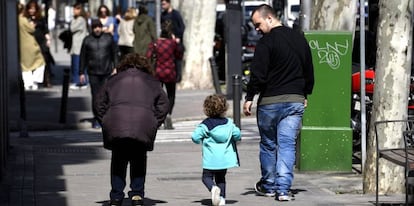 Un padre pasea junto a su hija por la calle.