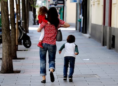 Dos niños acompañados de un adulto por el centro de Madrid durante la pandemia de coronavirus.