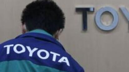 Un trabajador pasa por delante del logo de Toyota en la central de la empresa en Tokio.