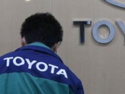 Un trabajador pasa por delante del logo de Toyota en la central de la empresa en Tokio.