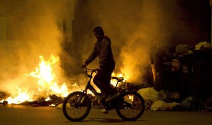 A child cycles past blazing trash cans in Jerez.