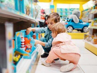 Dos niños eligen varios juguetes en una tienda de juguetes.