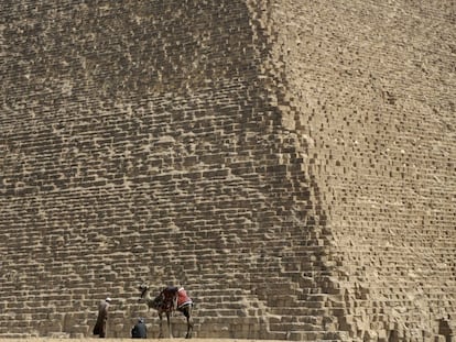 Guías turísticos esperan junto a su camello la llegada de turista junto a las pirámides de Giza (Egipto).