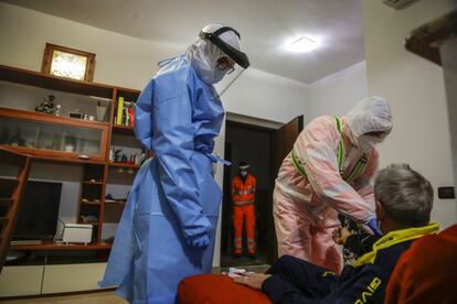 El médico Ruggero Gariboldi, a la derecha, mide el nivel de oxígeno en la sangre de un paciente sospechoso de tener covid-19, en Monza (Italia).