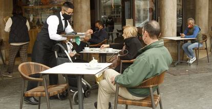 Un camarero atiende a varios clientes en la terraza de un bar en Palma, Mallorca (Islas Baleares).