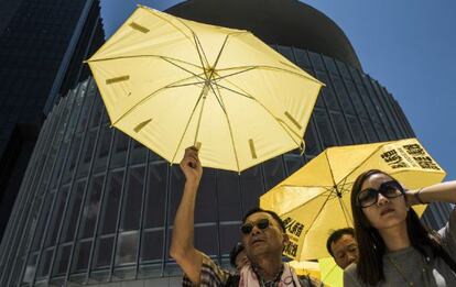 Manifestantes muestran paraguas como protesta.
