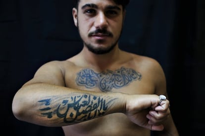 Alodi Issa, de 22 años, posa para la foto mostrando sus tatuajes con lemas religiosos musulmanes chiítas, en el sur de Beirut, Líbano. El tatuaje en árabe dice: "Oh, la venganza por Hussein. Ali, Fatima. 313, Oh Abu Fadel al-Abbas. En el antebrazo, el nombre completo de Abbas, otro hijo de Ali muerto en Kerbala (la gran batalla para los chiíes).