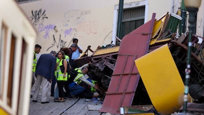 Investigadores trabajan junto a los restos del funicular siniestrado, este jueves en Lisboa.