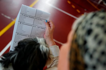 Una mujer sostiene una papeleta en un colegio electoral de la escuela Nyboder durante las elecciones al Parlamento Europeo, en Copenhague (Dinamarca).