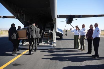 Personal del Instituto Nacional de Migración (INM) sube los féretros de algunos de los migrantes fallecidos en el incendio en Ciudad Juárez a un avión de la Fuerza Aérea Mexicana, el pasado 11 de abril. A la derecha, Francisco Garduño, comisionado del INM, supervisa la repatriación.