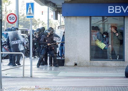La policía se enfrenta a los trabajadores del metal en huelga mientras se esconden dentro de un banco, en Cádiz, el pasado 23 de noviembre.