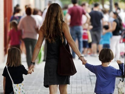 Una madre lleva a sus hijos al colegio.  