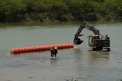 Trabajadores colocan una barrera flotante en el río Bravo, en la frontera con Piedras Negras (Coahuila), el 11 de julio.
