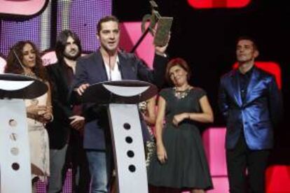 El cantante David Bisbal, acompañdo por Rosario Flores (i), Melendi (2i) y el presentador Jesús Vázquez (d), tras recibir el Premio Ondas al "Mejor programa de entretenimiento", La Voz, durante la gala de entrega de los Premios Onda 2012, que se celebra en el Gran Teatre del Liceu de Barcelona. EFE/Archivo