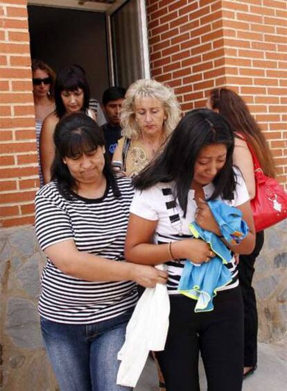 Nancy (derecha), madre de los niños, a la salida de su domicilio.