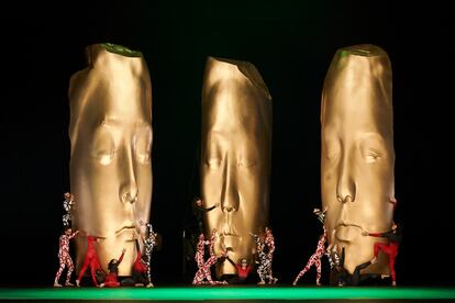 Tres bustos gigantes de color dorado presiden el escenario ante los bailarines en un momento de la ópera. / DAVID RUANO (Liceu)