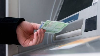 Un hombre saca dinero en un cajero automático.