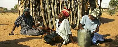 Mujeres de la tribu Basarwa de los Bosquimanos, descansan junto a su cabaña en el asentamiento Kaudawne, a las afueras de la reserva de Kalahari.